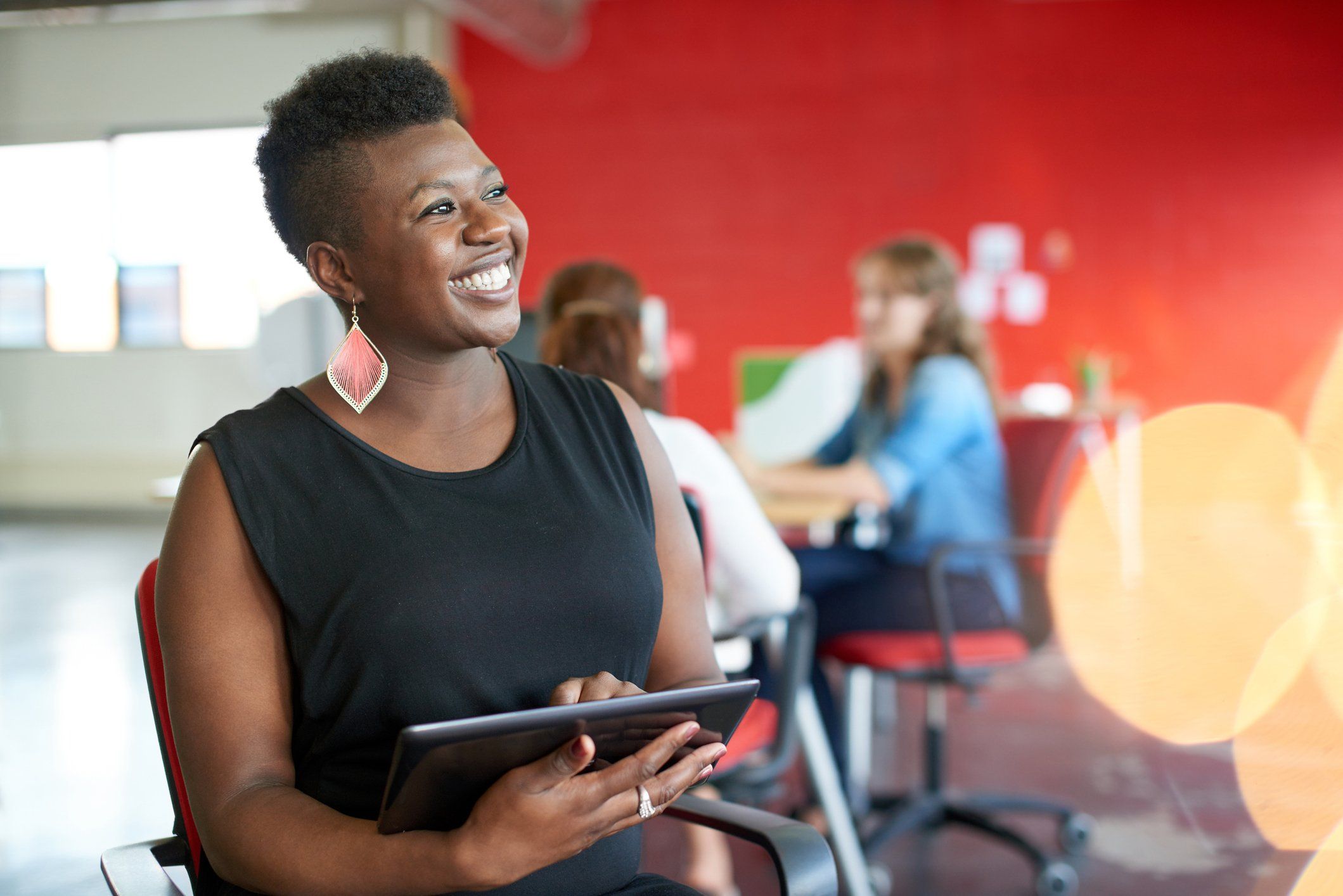 Woman smiling while holding tablet